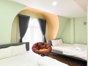 a room with two beds and a chair with a window at Lá Home - Căn Hộ Đà Lạt in Khu Chi Lăng