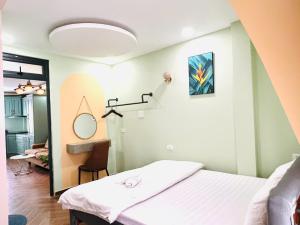 a bedroom with a bed and a mirror at Lá Home - Căn Hộ Đà Lạt in Khu Chi Lăng