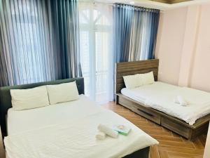 a bedroom with two beds and a window at Lá Home - Căn Hộ Đà Lạt in Khu Chi Lăng +9 photos