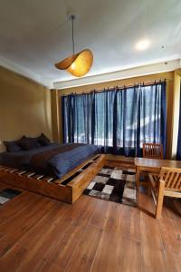 a bedroom with a large bed and a table at Oreos cafe and stay shangarh in Shangarh +32 photos