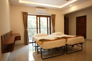 two beds in a room with a window at Shree Durga Paradise in Kalyānpur