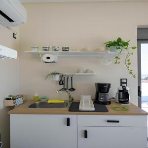 a kitchen with a sink and a counter top at Alba - Open Plan Apartment in Artemida