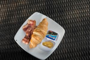 une assiette de nourriture avec du bacon et du pain et un en-cas dans l'établissement Villa Honey, à Montongbuwoh