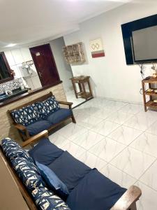 a living room with a couch and a flat screen tv at Aconchegante casa de Temporada em Búzios. in Armacao dos Buzios