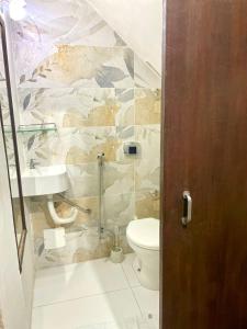 a bathroom with a toilet and a sink at Aconchegante casa de Temporada em Búzios. in Armacao dos Buzios