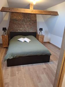 una camera da letto con un letto con due cuscini sopra di Le Lézard Flamand a Hazebrouck