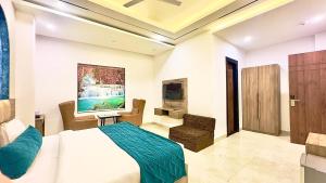 Un dormitorio con una cama, un televisor y una silla. en Hotel Premium Suites Near Delhi Airport, en Nueva Delhi