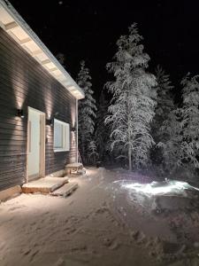 a house in the snow at night at Arctic Sauna Cabin in Rovaniemi