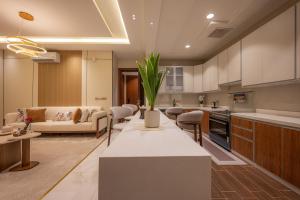 a kitchen and living room with a couch and a table at شقة فاخرة بثلاث غرف نوم دخول ذكي وموقف خاص in Jeddah