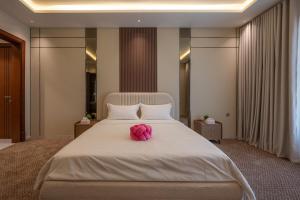 a pink stuffed animal sitting on top of a bed at شقة فاخرة بثلاث غرف نوم دخول ذكي وموقف خاص in Jeddah