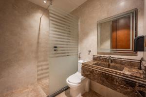 a bathroom with a toilet and a sink and a shower at شقة فاخرة بثلاث غرف نوم دخول ذكي وموقف خاص in Jeddah