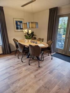 a dining room with a wooden table and chairs at Buitenplaats Appelhoeve in Appelscha