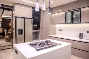 eine Küche mit weißen Schränken und einem Herd mit Backofen in der Unterkunft Pinnacle Residences, Kathmandu in Kathmandu