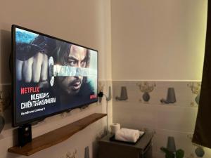 a flat screen tv hanging on a wall in a bathroom at ấm iu Hotel in Ho Chi Minh City