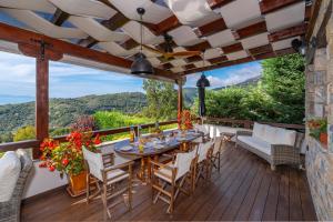 a patio with a table and chairs on a deck at Aenaon Villa with Private Pool Panoramic view in Miléai