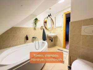 a bathroom with a bath tub and a sink at Alpinlake Apartments - Grünau im Almtal in Grünau im Almtal +31 photos