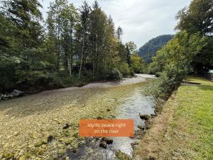 a sign next to a river that says up like peace right on the river at Alpinlake Apartments - Grünau im Almtal in Grünau im Almtal