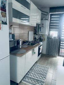 Craiova International AirportMagnolia apartament K&A的带水槽和冰箱的白色厨房