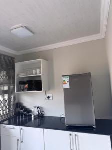 a kitchen with a black counter top and a refrigerator at Ella Guest House in Pretoria +5 photos