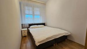 une petite chambre avec un lit et une fenêtre dans l'établissement M przy Broniewskiego, à Łomża