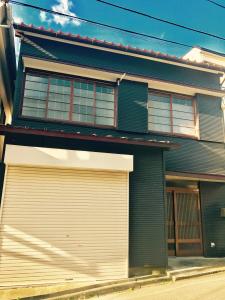 une maison avec une porte de garage et 2 fenêtres dans l'établissement 三崎港至近一軒家, à Moroiso