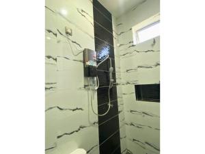 a bathroom with a shower with black and white tiles at Hijrah De La Villa Parit Buntar Nibong Tebal Penang in Nibung Tebal +37 photos