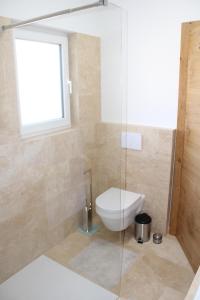 a bathroom with a toilet and a window at Panorama Loft Bad Aussee in Bad Aussee