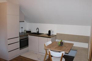 a small kitchen with a wooden table and a table and chairs at Panorama Loft Bad Aussee in Bad Aussee +5 photos