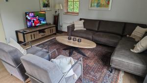 a living room with a couch and a table at Buitenplaats Appelhoeve met sauna en hottub in Appelscha