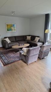 a living room with a couch and a table at Buitenplaats Appelhoeve met sauna en hottub in Appelscha +40 photos