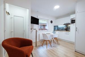 a white kitchen with a table and chairs in a room at Studio centre thermal touristique - Casa Amnéville in Amnéville