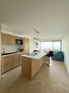 a kitchen with wooden cabinets and a large island in a room at L'Ukiyo-e - Vue Mer et Sauna by Alto Service in Le Barcarès
