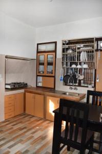 ThapathaliKathmandu Apartment 1BHK Thamel 5 min walk 0 Floor的配有木制橱柜、桌子和椅子的厨房