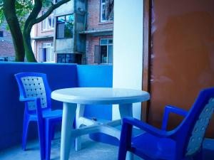 ThapathaliMakalu Apartment 2BHK Thamel 5 min walk 1st Floor的天井上摆放着一张蓝色的桌子和两把椅子