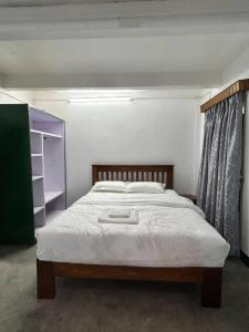 ein Schlafzimmer mit einem großen Bett mit Holzrahmen in der Unterkunft Buddha Apartment - Traditional house in Thamel in Thapathali