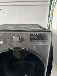 ThapathaliGanesh Apartment, Traditional house in Thamel的黑色洗衣机的门打开