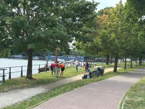 a group of people walking on a path next to a river at Dokstudio50 in Ghent