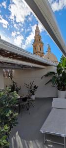 a balcony with a bench and a clock tower at Lithos house pt 1p e 2p in Monopoli