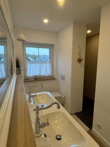 a white bathroom with a sink and a window at Landhausstübchen 105qm mit Balkon-2 Schlafzimmer-Bad-WC-WiFi-Kaffeemaschine-Waschmaschine-Trockner-Föhn-Handtücher und Bettwäsche-sehr familienfreundlich in Eichenzell +52 photos