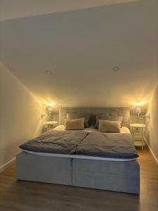 a bedroom with a large bed with two tables at Landhausstübchen 105qm mit Balkon-2 Schlafzimmer-Bad-WC-WiFi-Kaffeemaschine-Waschmaschine-Trockner-Föhn-Handtücher und Bettwäsche-sehr familienfreundlich in Eichenzell