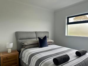 a bedroom with a bed with blue pillows and a window at McCrae Retreat Brand New Home in McCrae