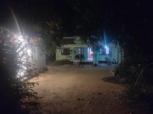 a house at night with two lights on it at Katadi beach coral cottage in Thanniyam