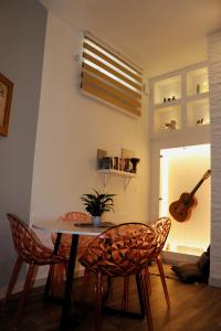 a dining room with a table and chairs and a guitar at Zen Loft Getaway in Is-Swieqi +13 photos