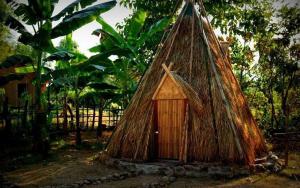 a small hut with a roof in a garden at The Last Resort in Don Det