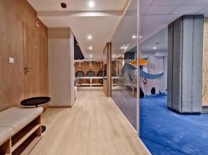 une salle de jeux pour enfants avec un toboggan et un sol de jeu dans l'établissement Apartamenty Nexo Q4Apartments, à Puck