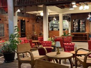 a restaurant with wooden tables and red chairs at Khom Chiang Mai in Chiang Mai