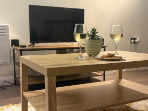 - une table avec 2 verres de vin et une télévision dans l'établissement Blue Mill - On The High Street, à Swindon