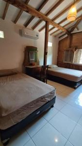 een slaapkamer met een bed en een bureau in een kamer bij Sunset Side Gili Home in Gili Air