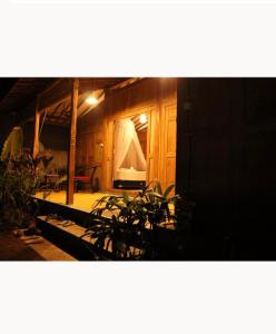 een kamer met planten in een houten gebouw bij Sunset Side Gili Home in Gili Air +3 foto's