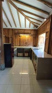 ギリ・アイルにあるSunset Side Gili Homeの大きなキッチン(木製キャビネット、カウンタートップ付)